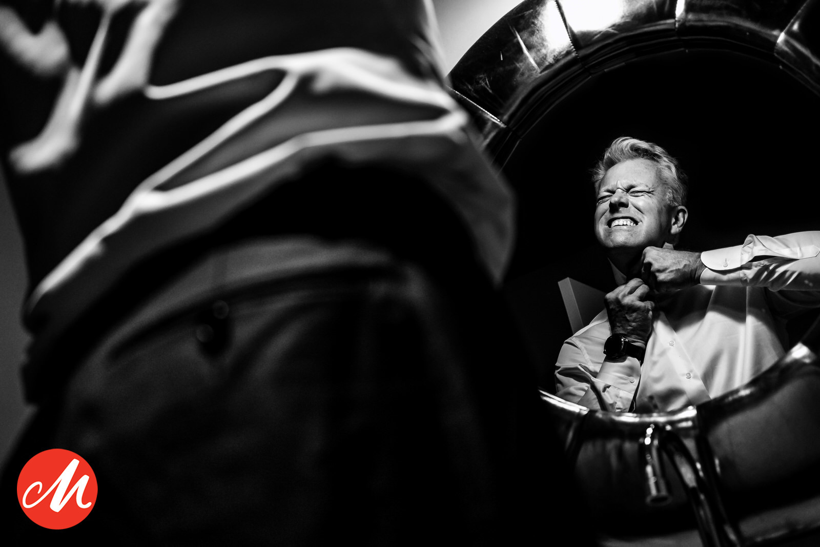 prijswinnende foto van een bruidegom die moeite heeft het bovenste knoopje van zijn overhemd dicht te krijgen