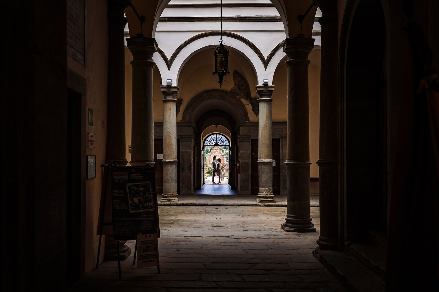 bruidspaar in het portiek van een palazzo in toscane
