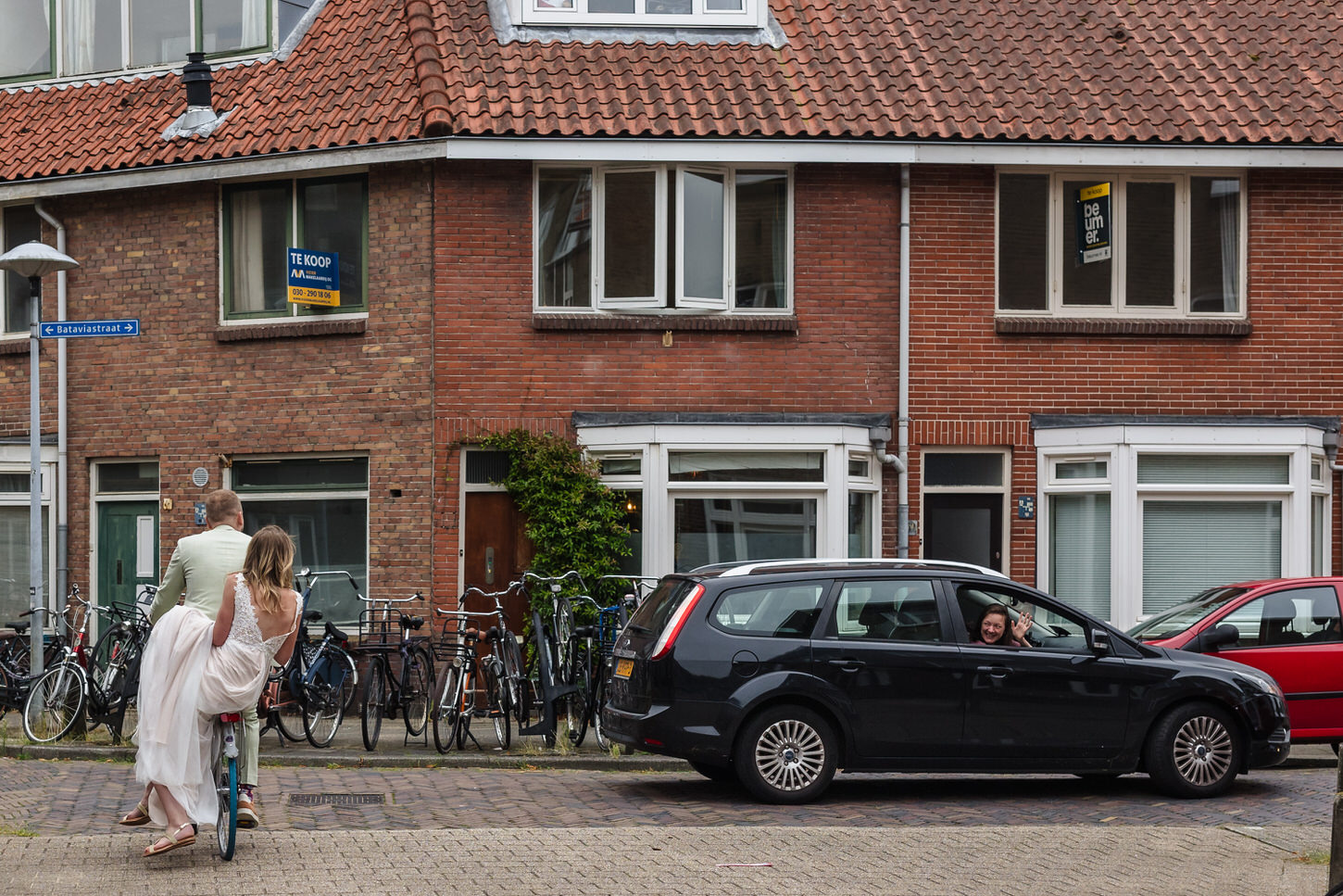bruidspaar fietst door oude straten van utrecht