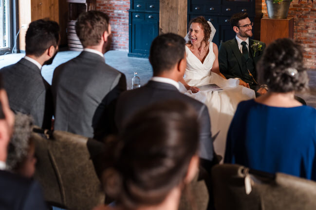 lachende bruid tijdens ceremonie vastgelegd door een trouwfotograaf