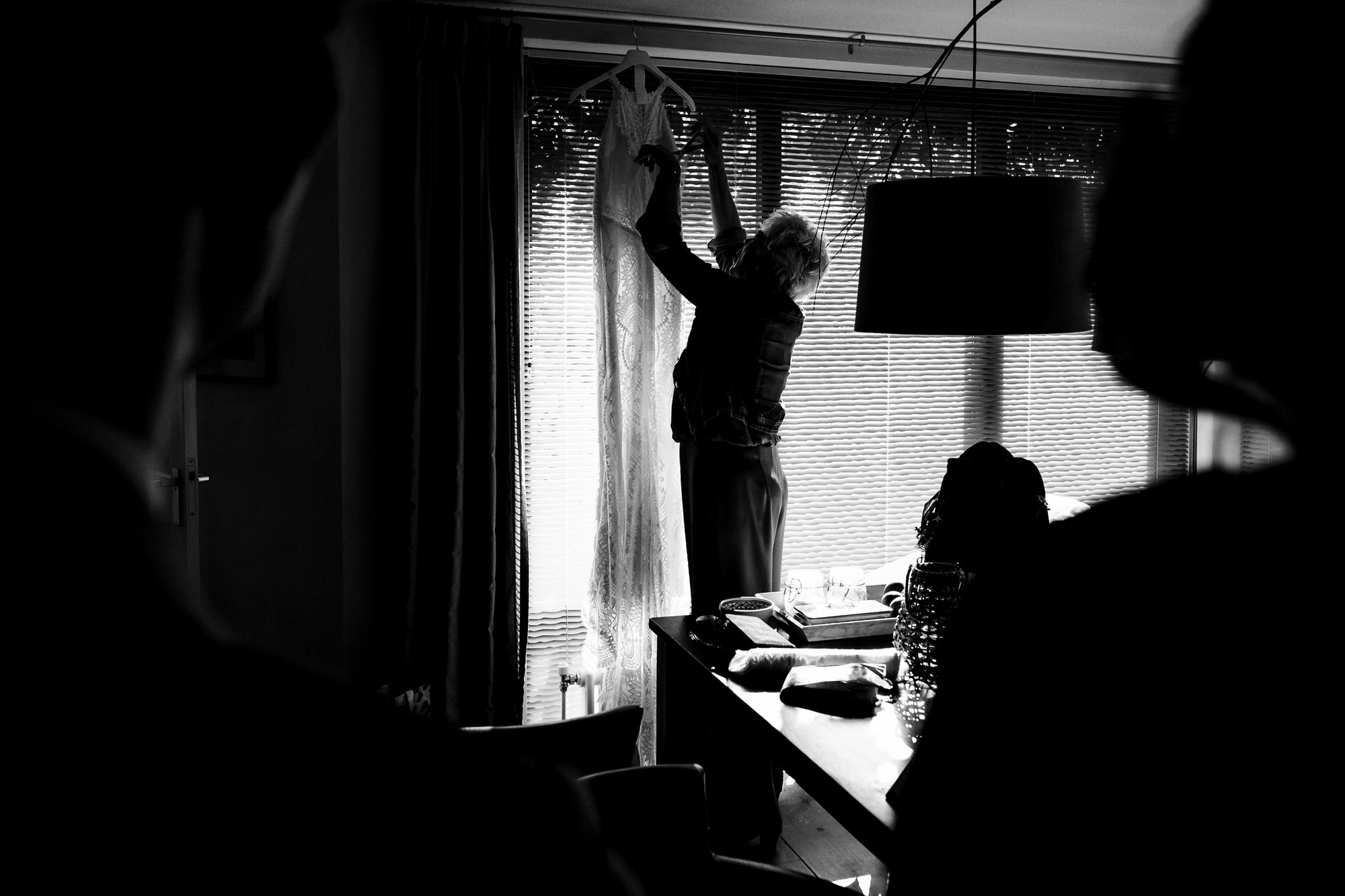 moeder van de bruid pakt de trouwjurk