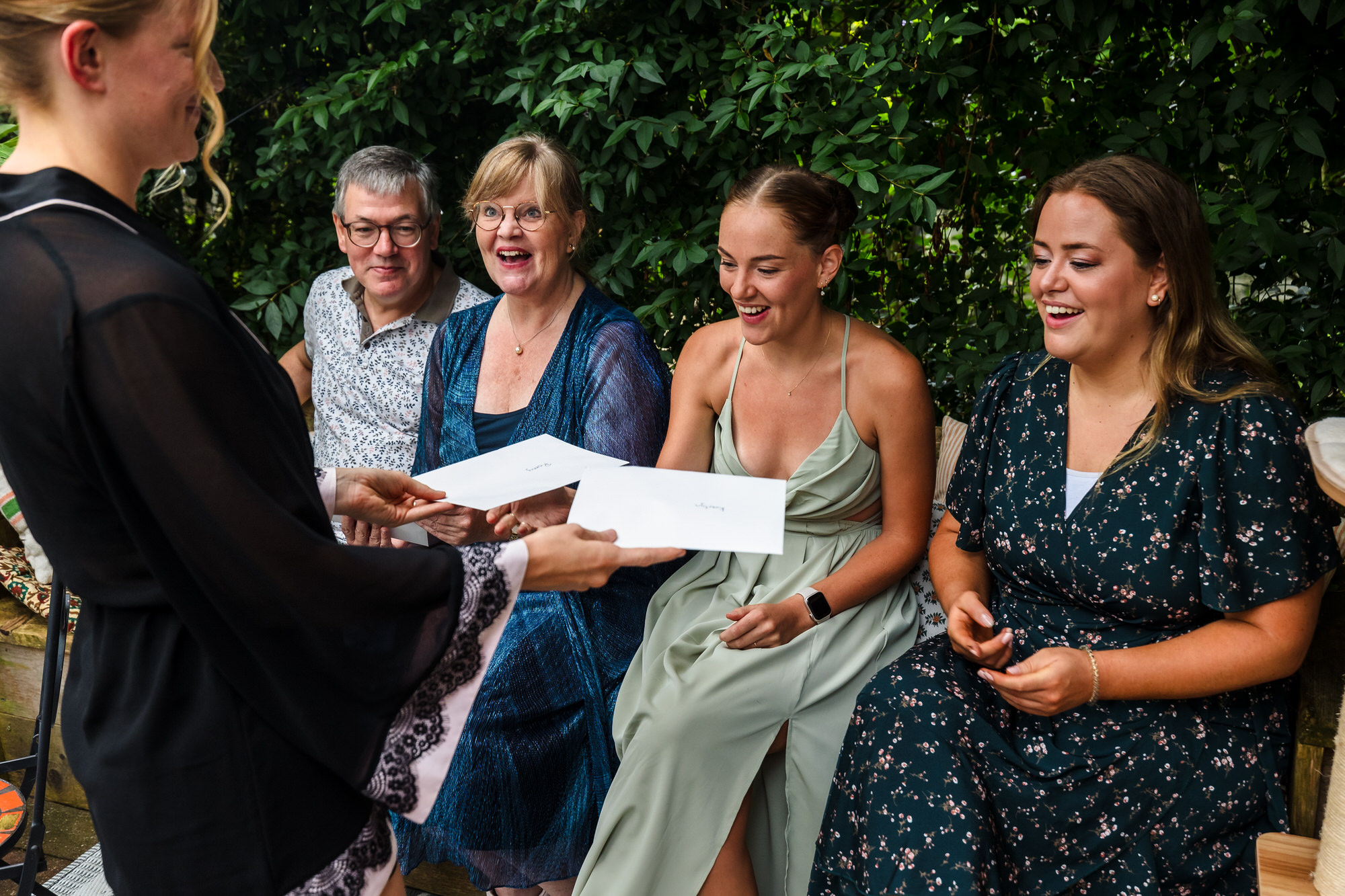 bruid overhandigt brieven aan ouders en zussen
