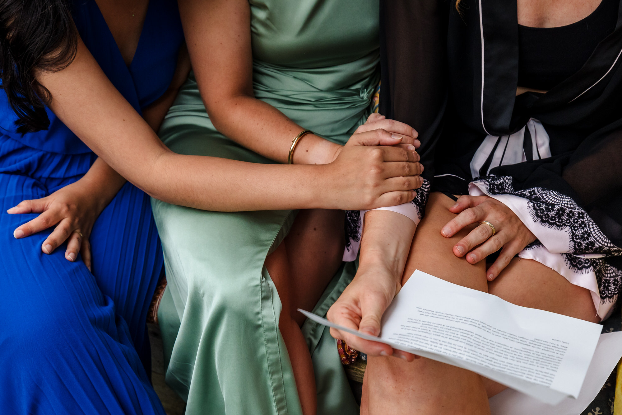 detailfoto van bruid en bruidsmeisjes die elkaar vasthouden