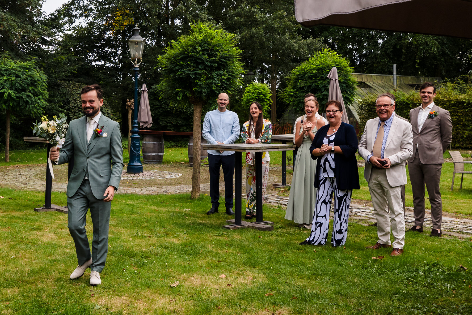 bruidegom en familie wachten op de first look met de bruid