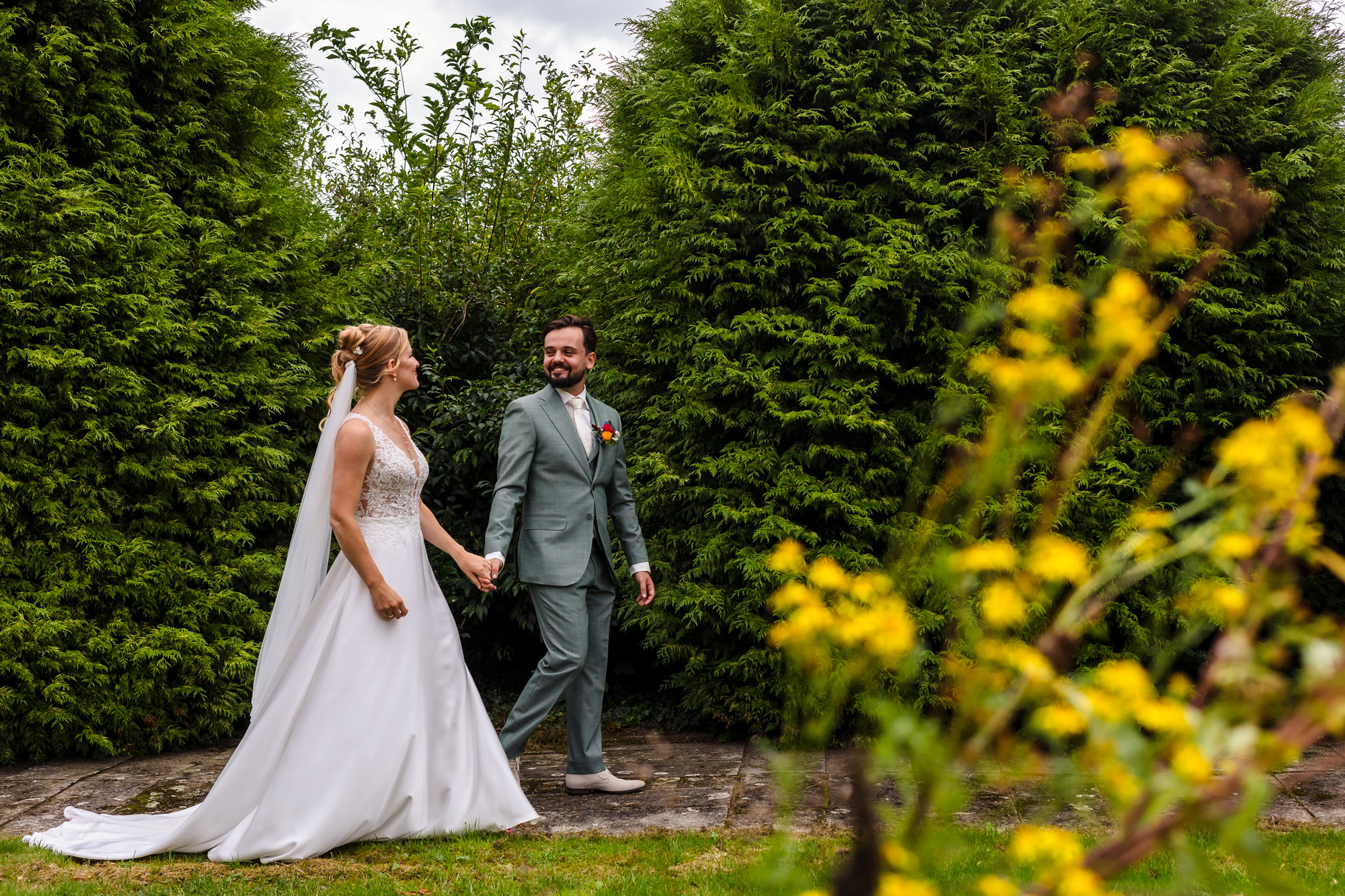 bruidspaar wandelt in de tuin tijdens zomerbruiloft in heumen