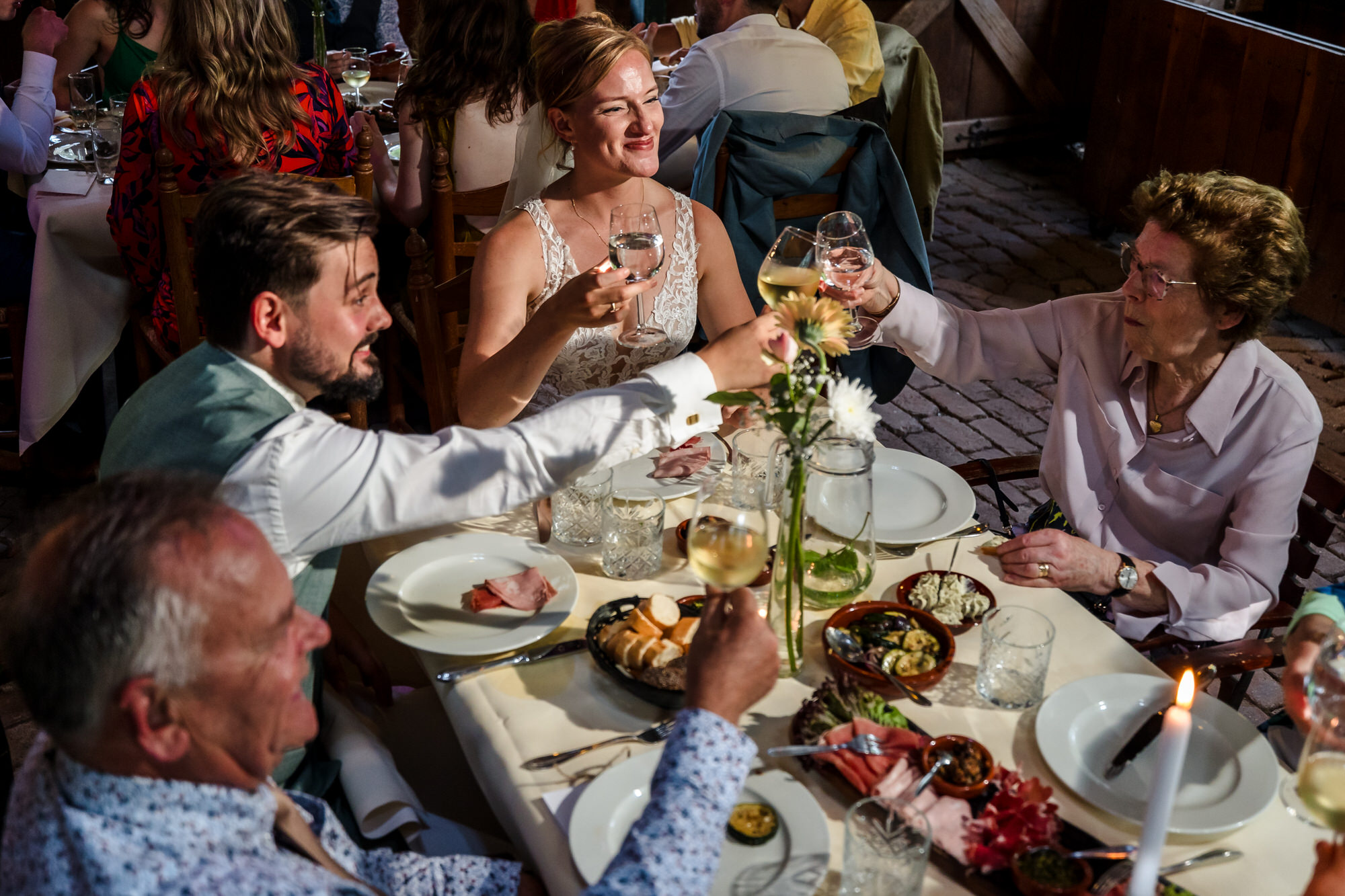 bruidspaar proost met familie aan dinertafel in heumen
