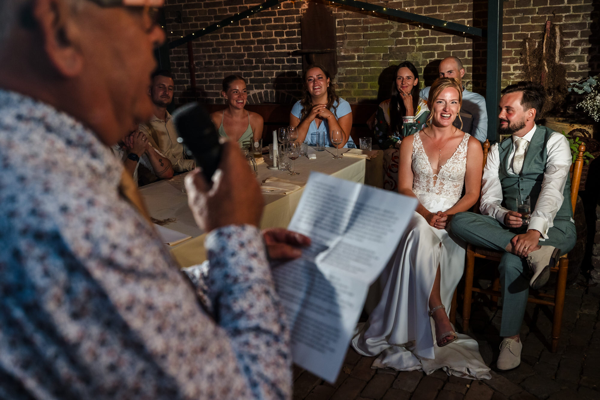vader spreekt bruidspaar toe tijdens bruiloftsdiner