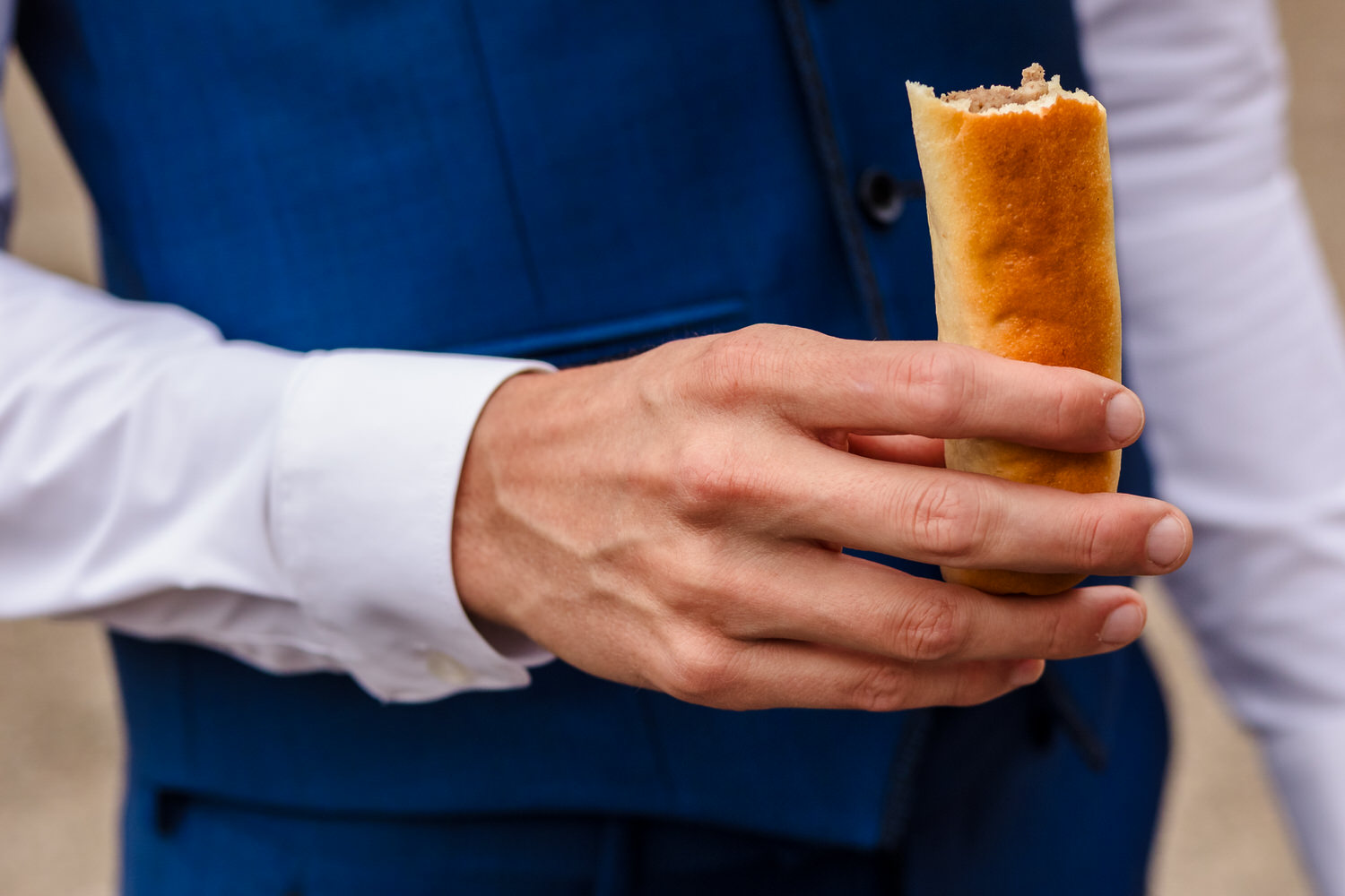 man eet worstenbroodje op trouwlocatie in brabant