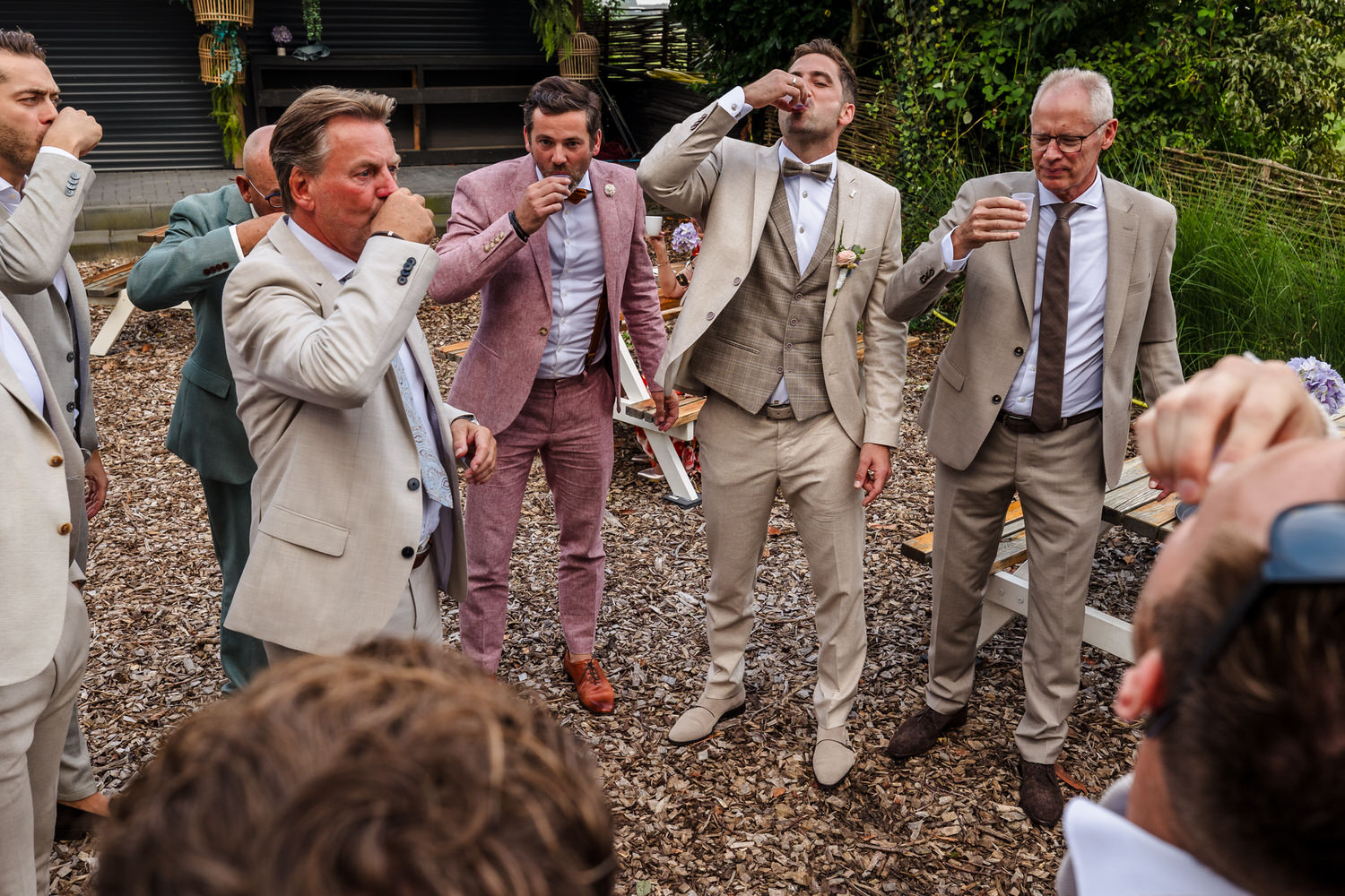 mannen drinken shotjes tijdens bruiloft
