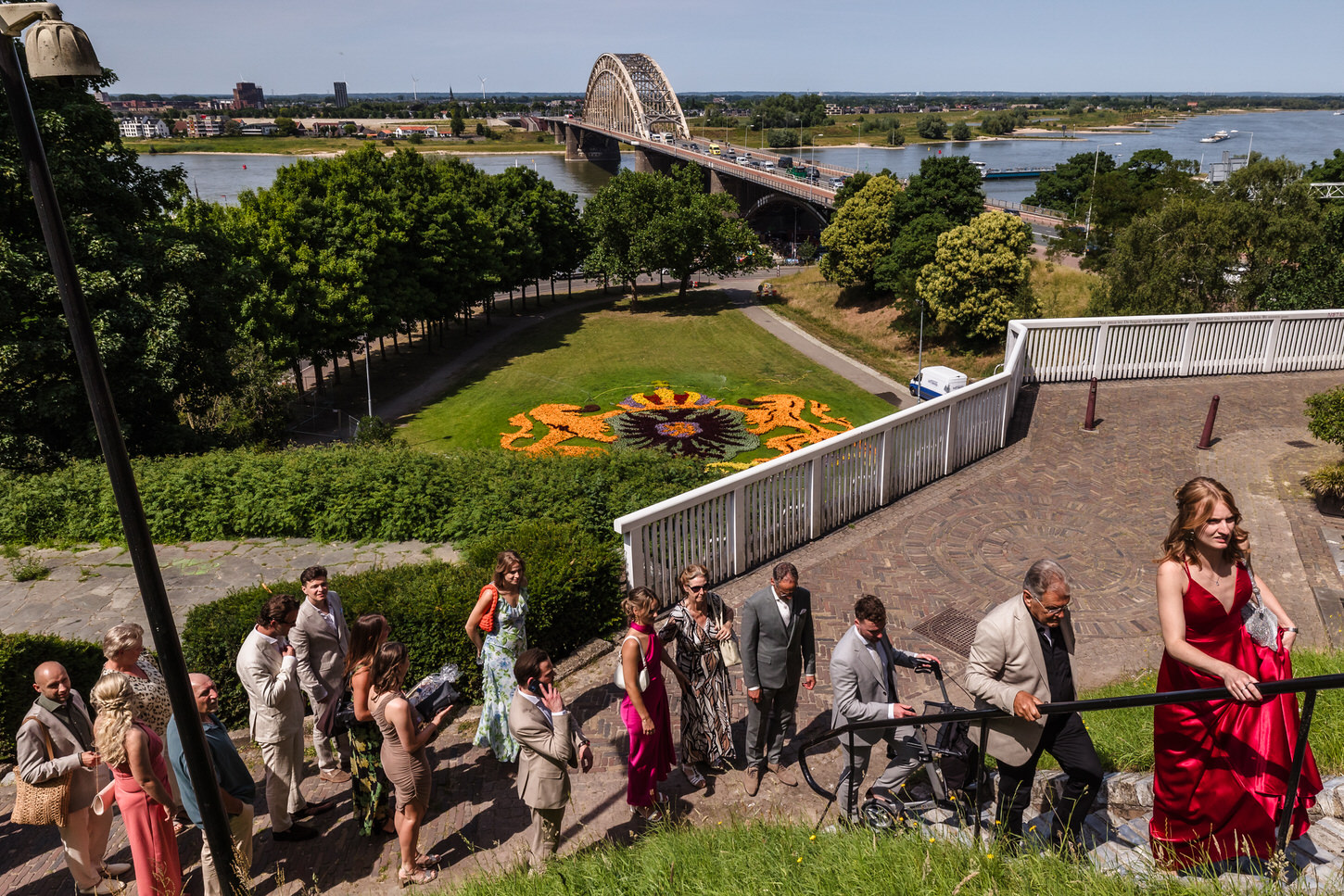 bruidspaar en gasten komen aan bij het belvedere, op de achtergrond de waal en de waalbrug