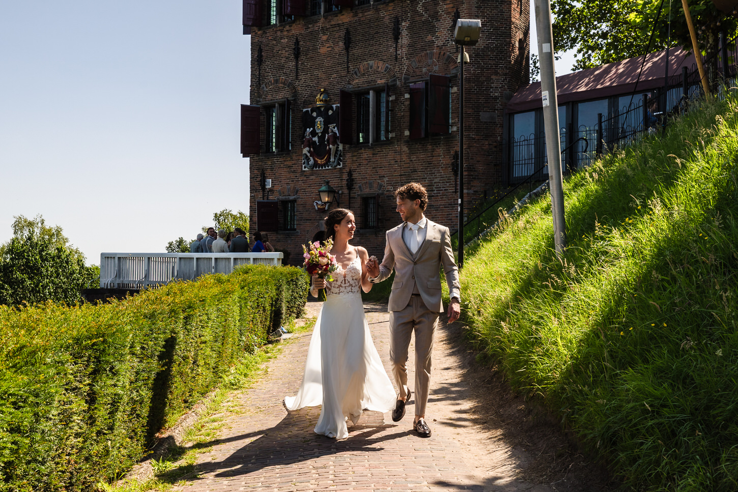 wandelend bruidspaar met het belvedere van nijmegen op de achtergrond
