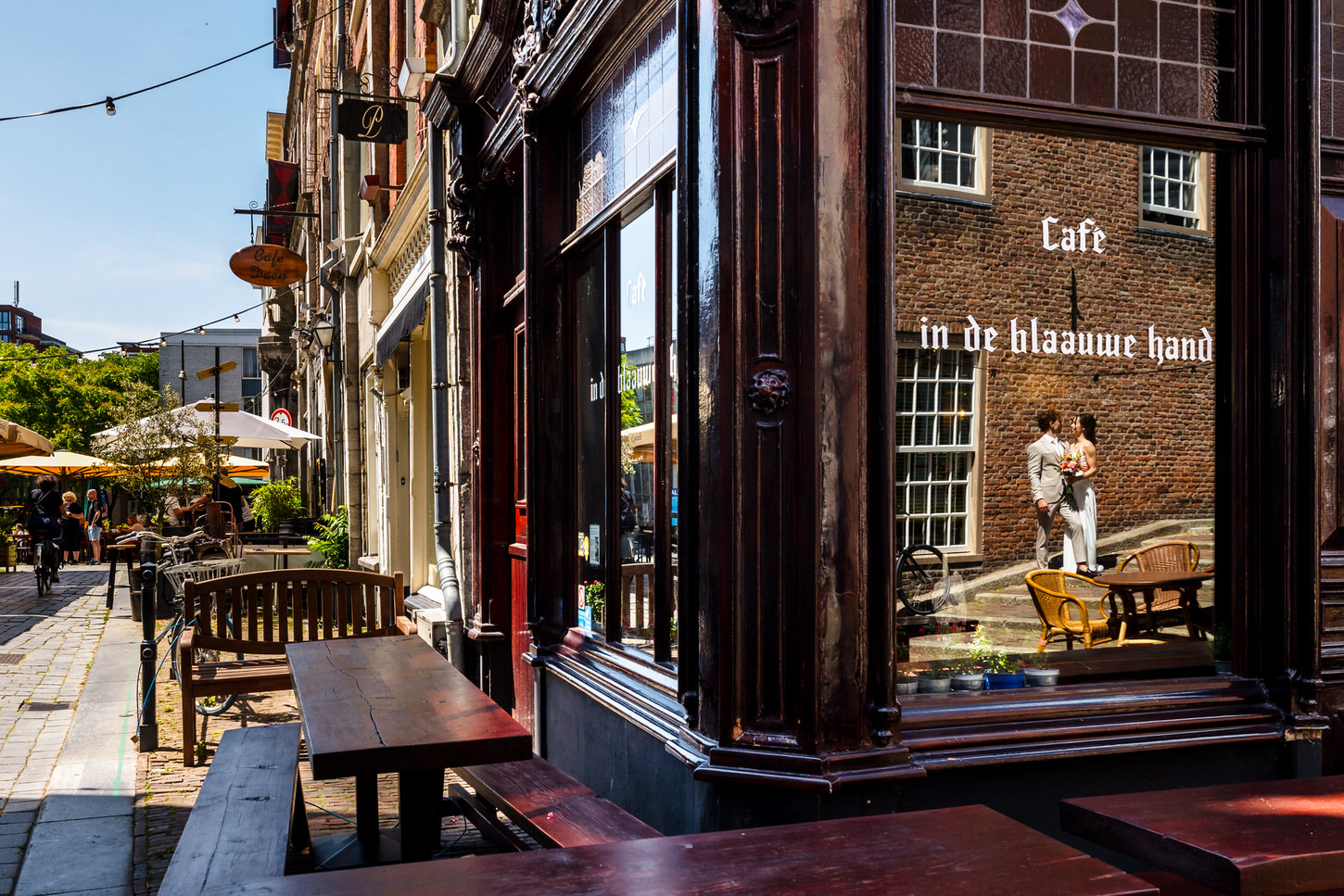 weerspiegeld bruidspaar in het raam van cafe de blaauwe hand in nijmegen