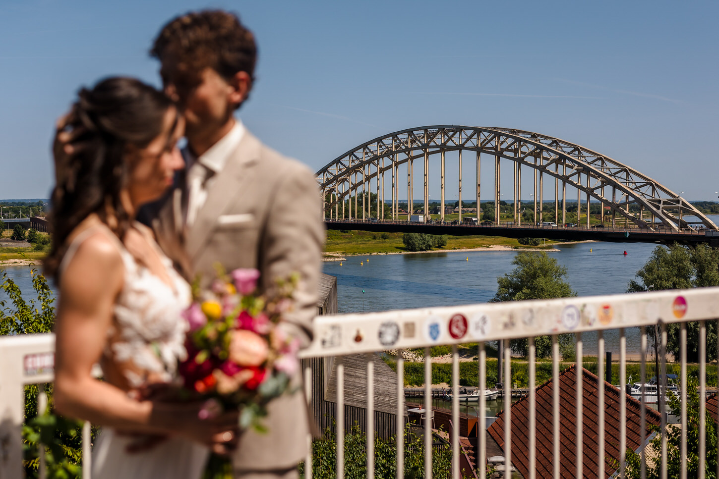 bruidspaar met de waalbrug van nijmegen op de achtergrond