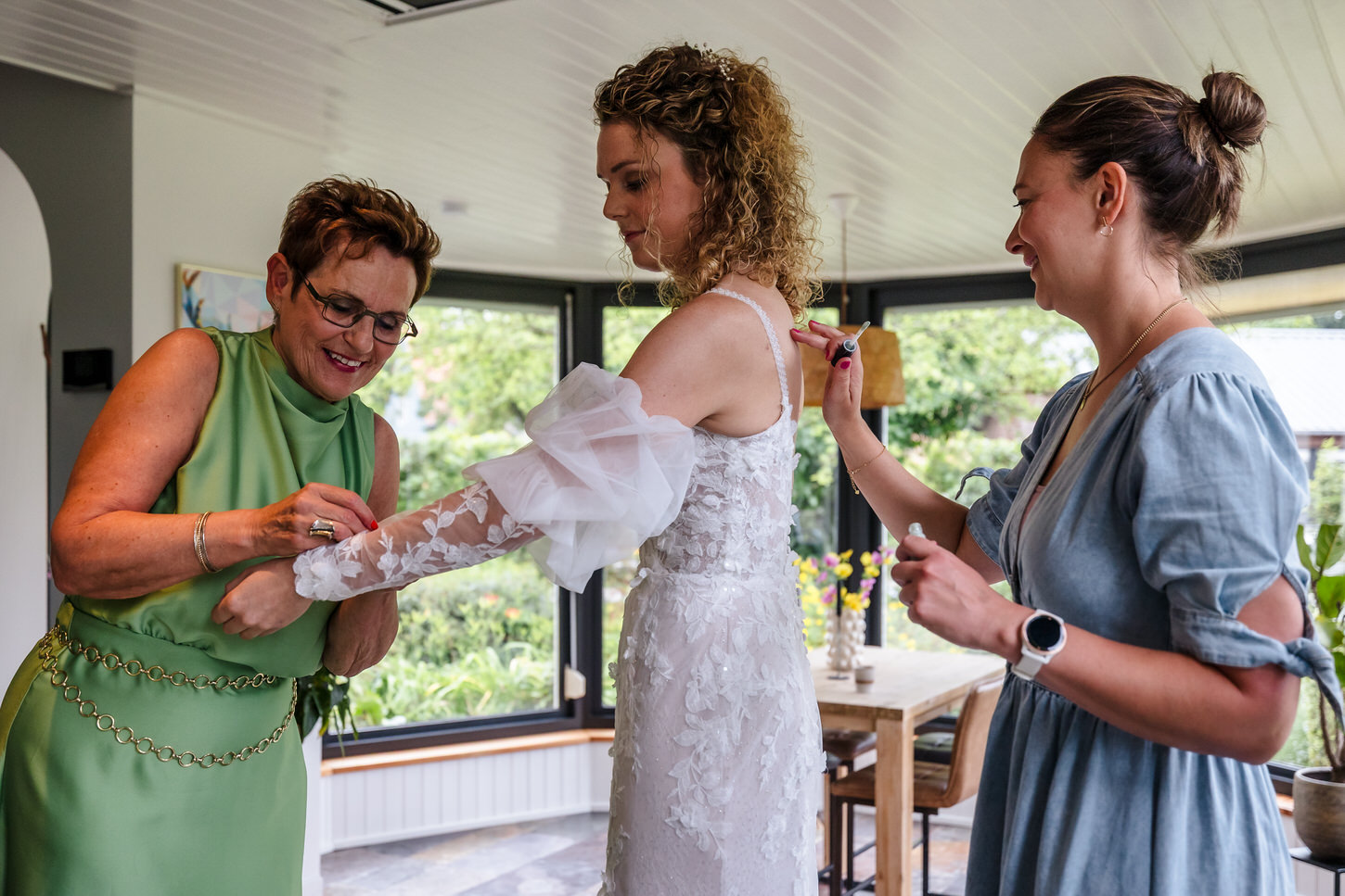 bruid trekt trouwjurk aan