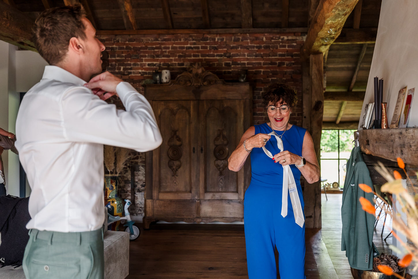 moeder helpt bruidegom met de stropdas tijdens een bruiloft in noord-limburg