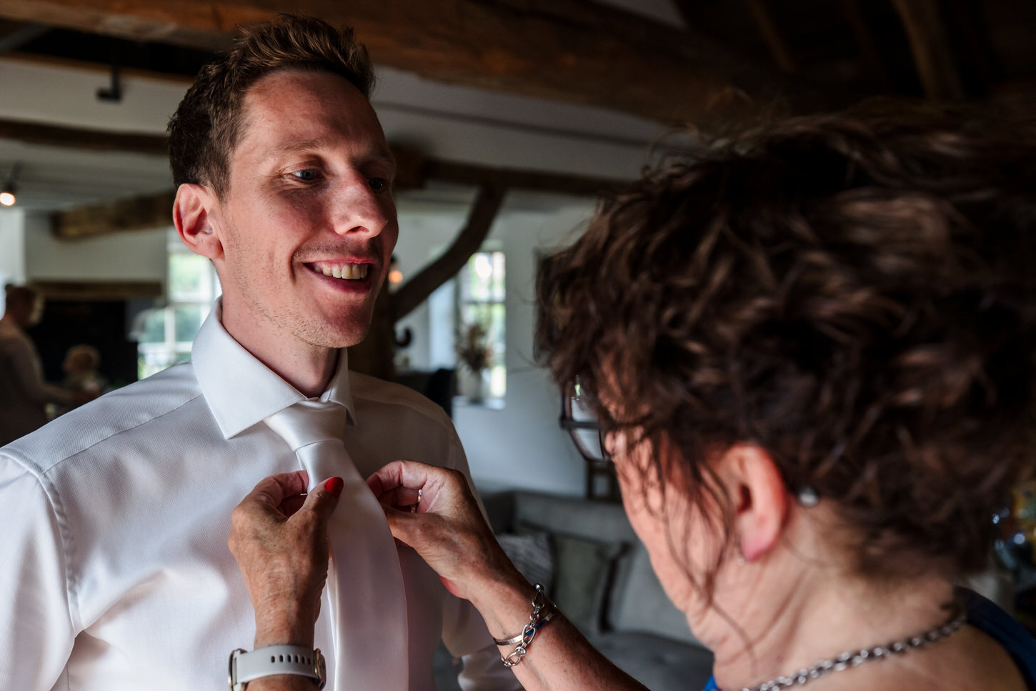 moeder helpt bruidegom met stropdas