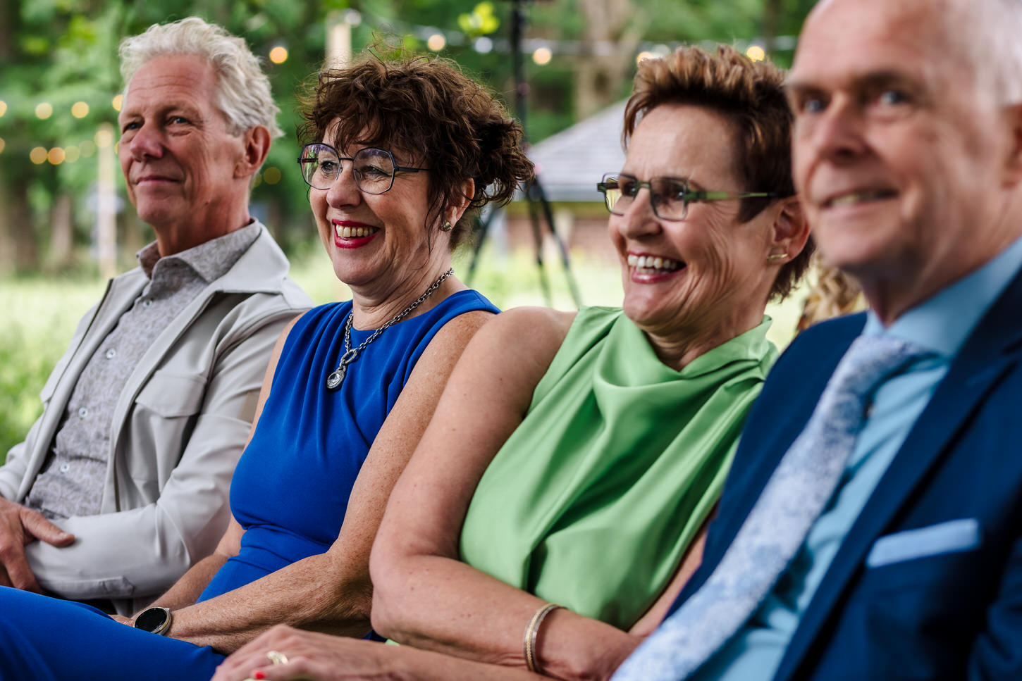 familieleden van het bruidspaar luisteren naar een speech