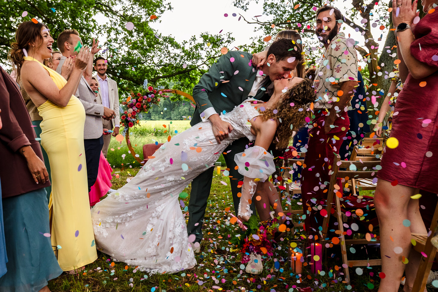 bruiloftsgasten gooien confetti naar bruidspaar