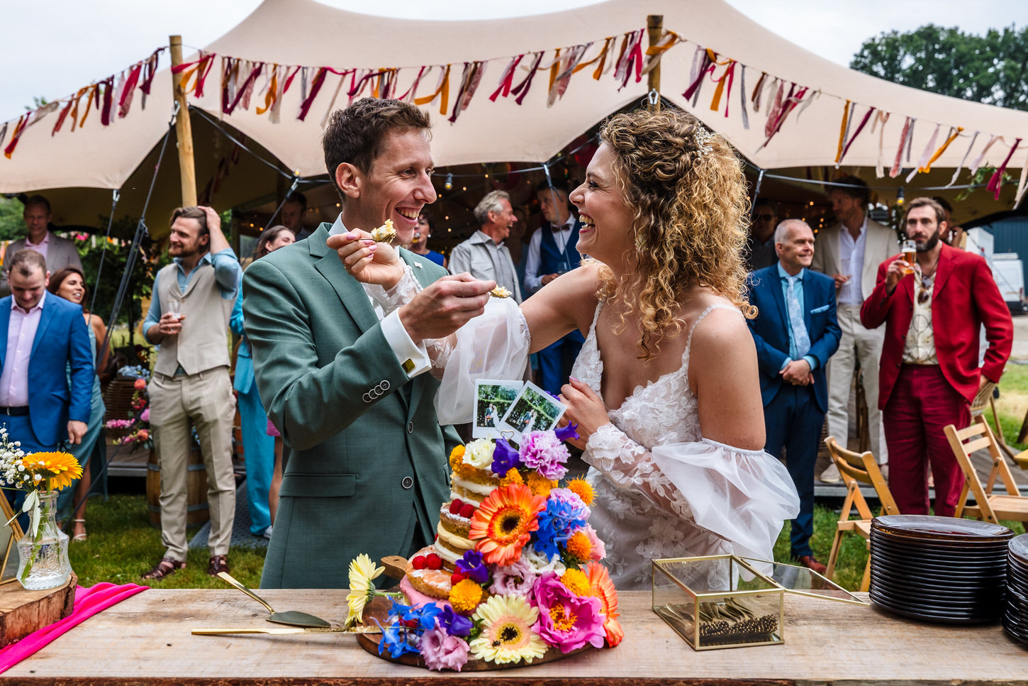 bruidspaar snijdt bruidstaart aan tijdens zomerse bruiloft in noord-limburg