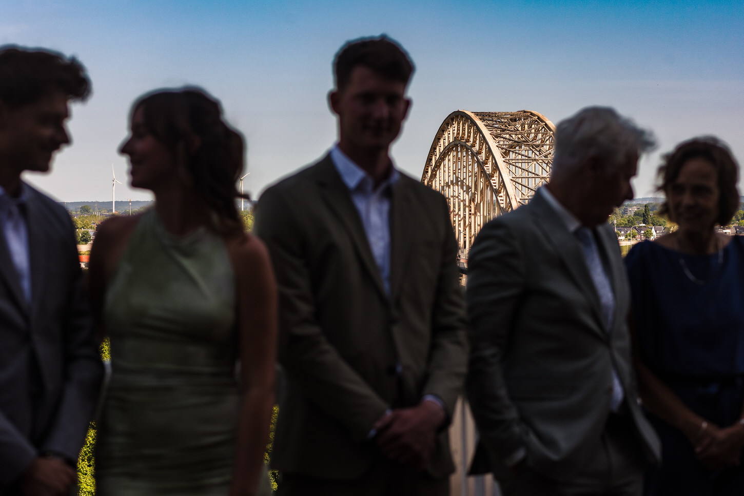 familie van bruid en bruidegom met de waalbrug op de achtergrond