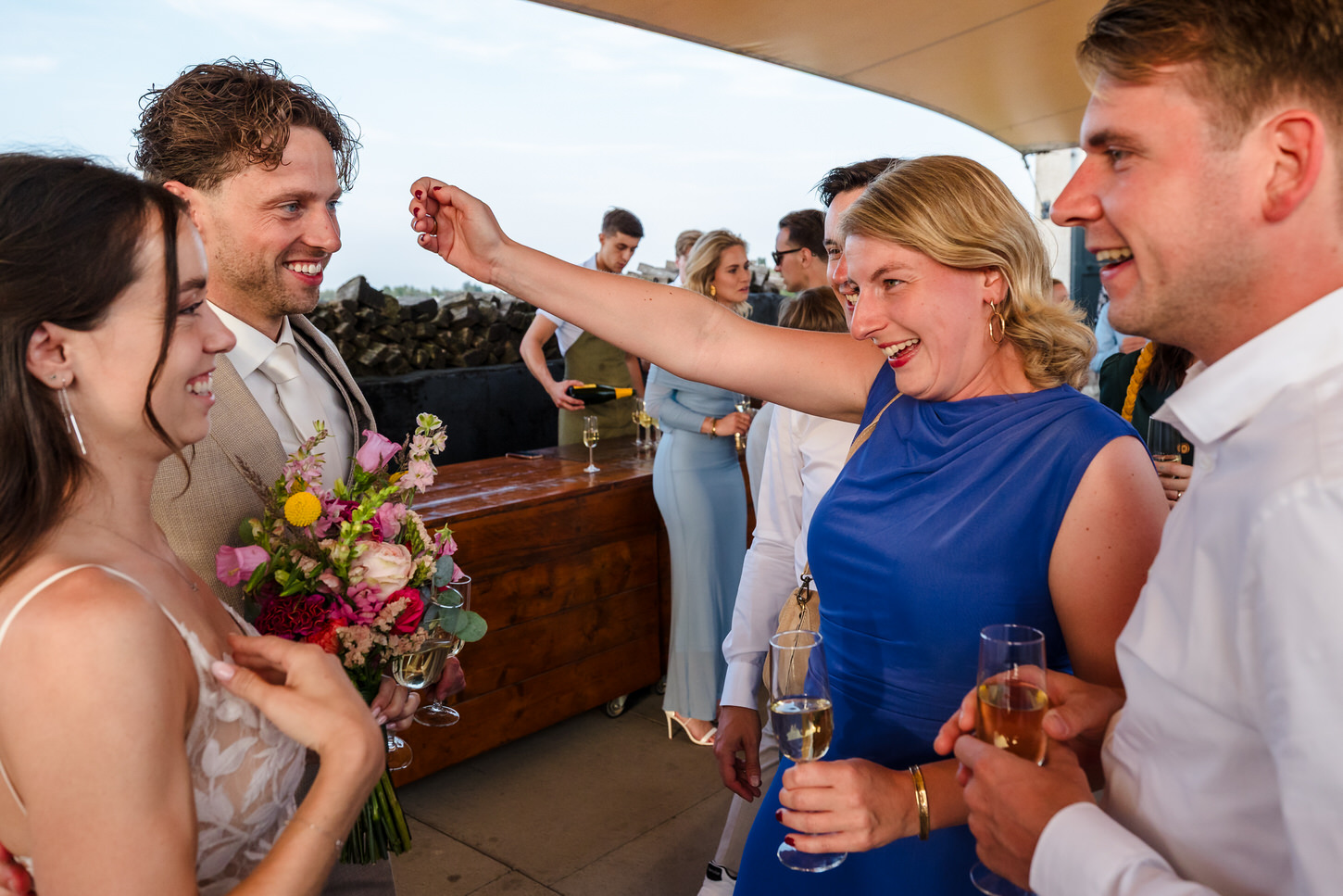 avondgasten feliciteren bruidspaar op dakterras van fort lent