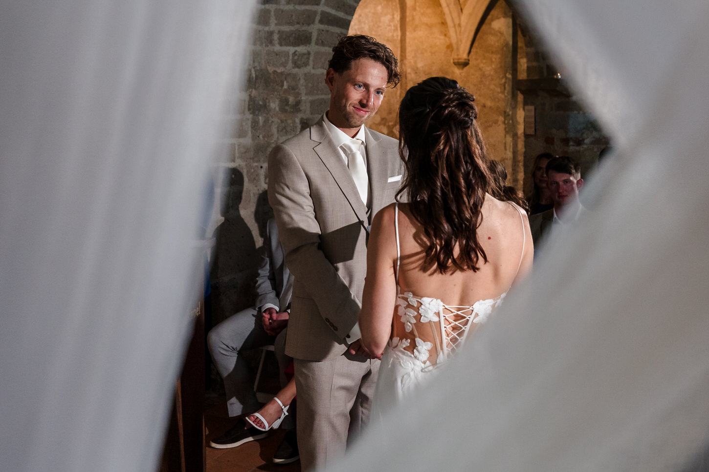 bruidegom luistert naar bruid die gelofte uitspreekt