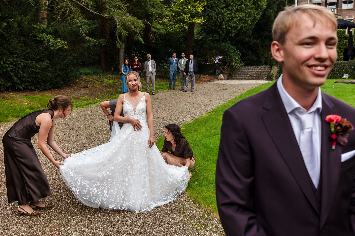 bruid maakt zich klaar voor de first look, op de voorgrond wacht de bruidegom