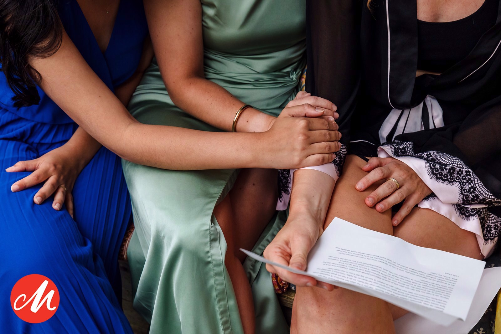 detailfoto van bruid die een brief leest met twee vriendinnen