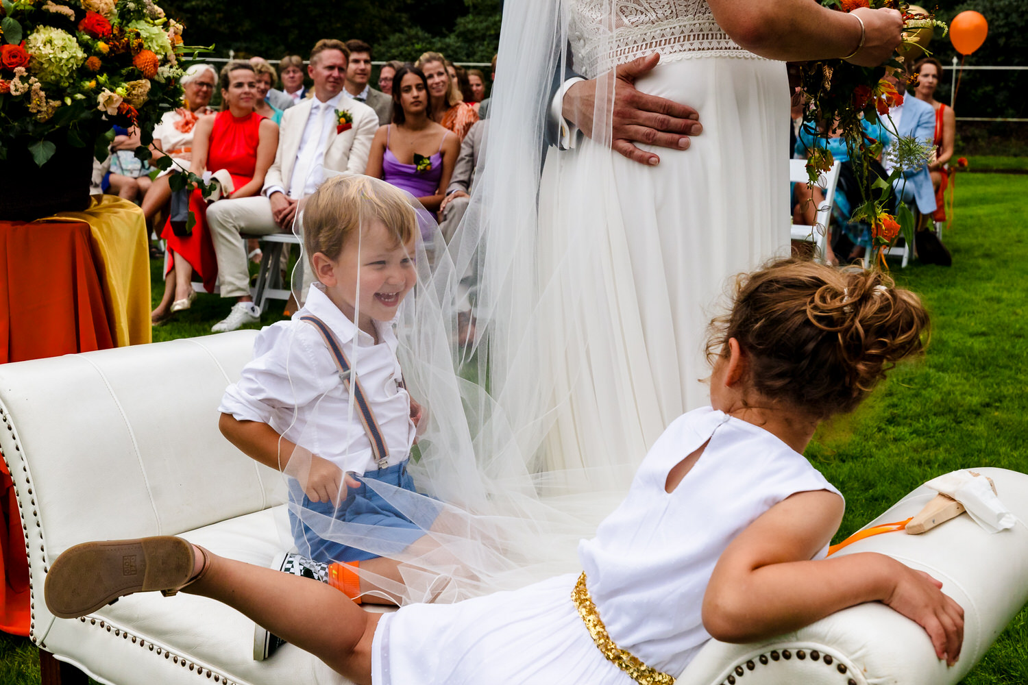 voorbeeld van documentaire trouwfotografie: kinderen spelen met bruidssluier tijdens ceremonie