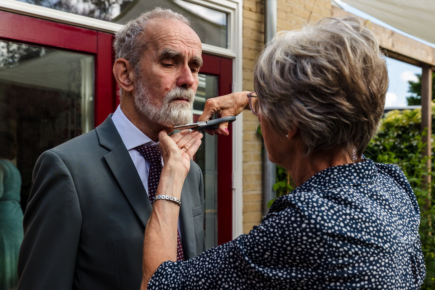 moeder van de bruid knipt baard van vader van de bruid