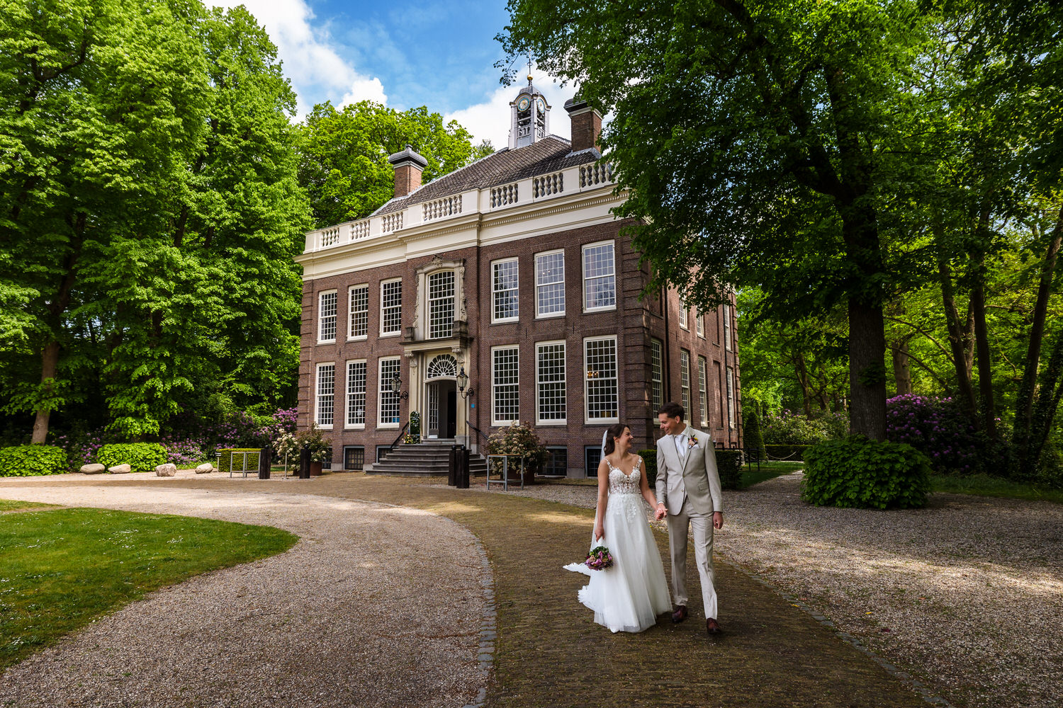 bruidspaar met op de achtergrond het landhuis van buitenplaats sparrendaal
