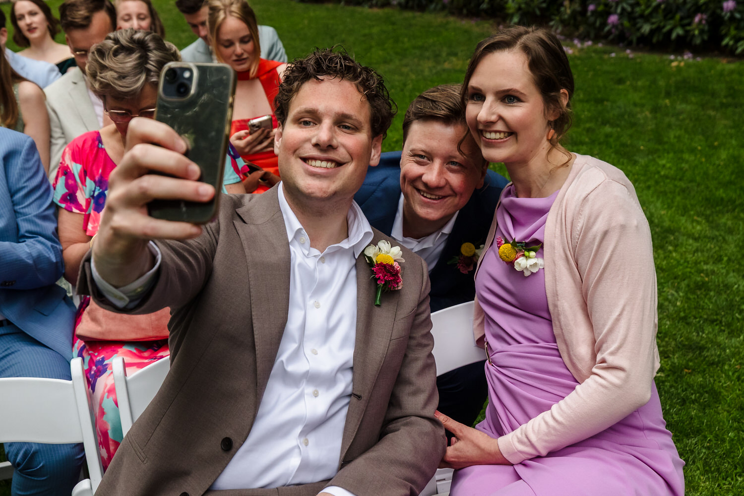 bruiloftsgasten nemen een selfie vlak voordat de ceremonie begint