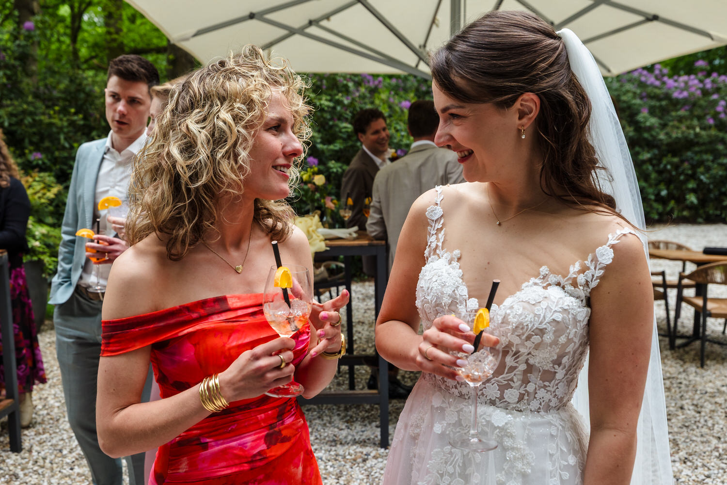lachende bruiloftsgasten met aperol spritz tijdens receptie