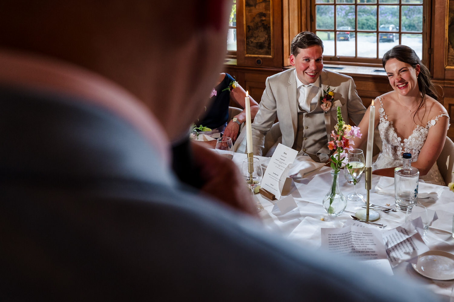 bruidspaar luistert naar speech in de raadzaal van buitenplaats sparrendaal tijdens het diner