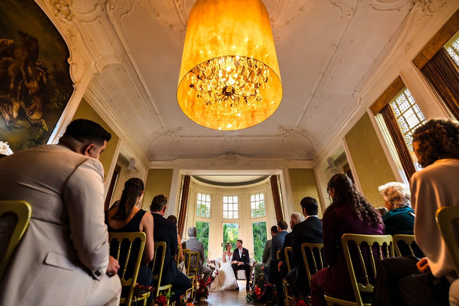 bruidspaar tijdens ceremonie in de parkzaal van trouwlocatie kasteel de hooge vuursche