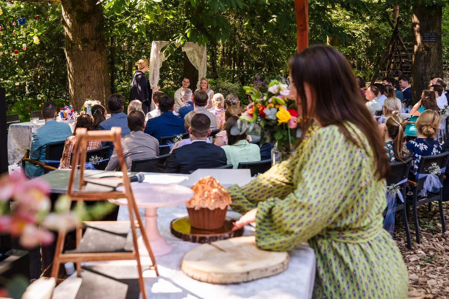 bruidspaar tijdens de ceremonie bij meneer van eijck in oisterwijk, op de voorgrond wordt de bruidstaart klaargezet