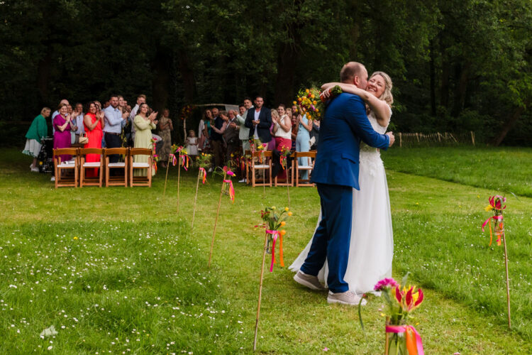bruidspaar omhelst elkaar na afloop van de ceremonie van hun bruiloft bij landgoed brakkesteyn in nijmegen