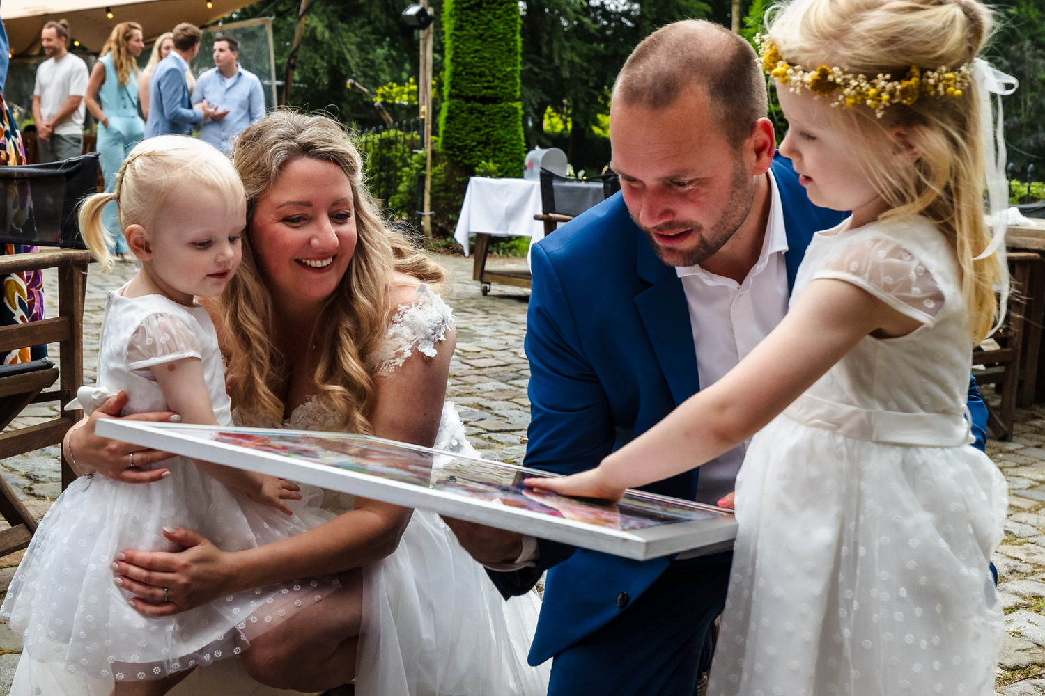 gehurkt bruidspaar krijgt cadeau van bruidsmeisjes