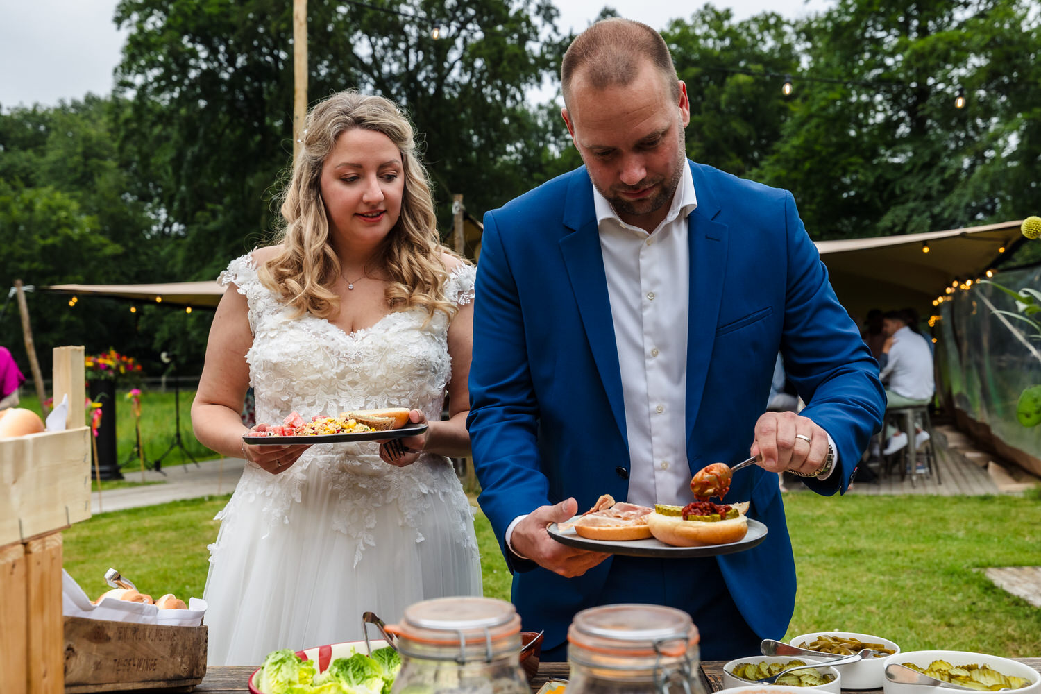 bruidspaar schept eten op voor diner bij landgoed brakkesteyn