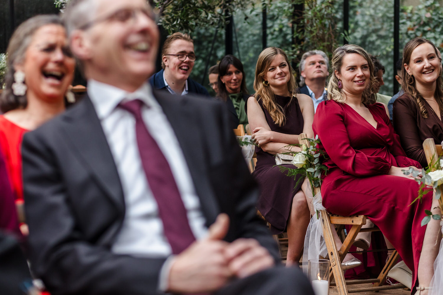 lachende bruiloftsgasten tijdens een ceremonie in de boskas in nijmegen