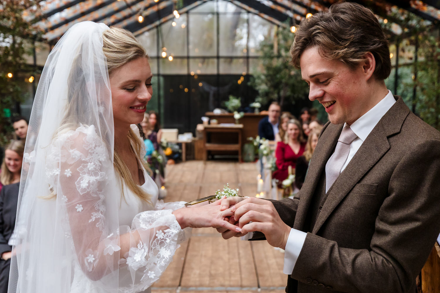 bruidspaar wisselt ringen uit tijdens ceremonie in de boskas in nijmegen